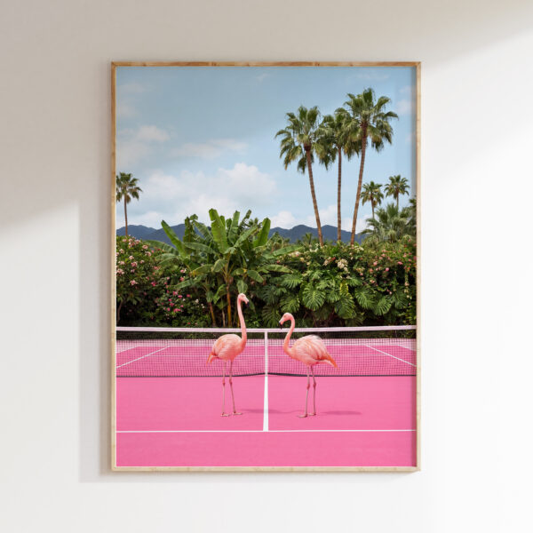 Framed artwork of two pink flamingos on a vivid pink tennis court with palms and mountains