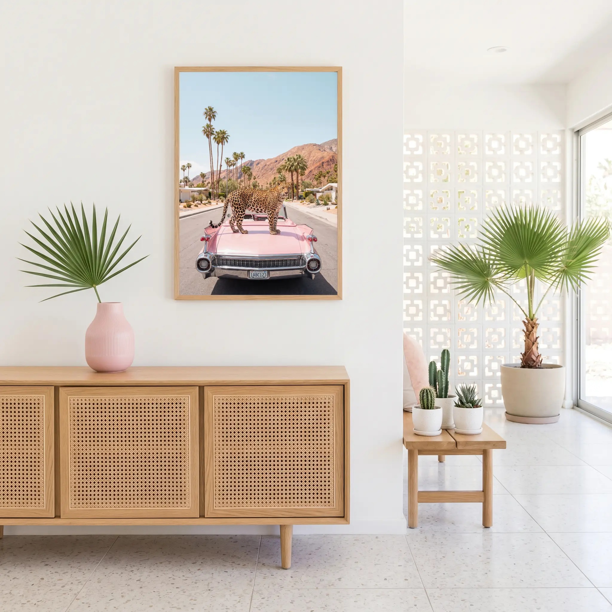 Leopard on Pink Cadillac Eldorado framed wall art above a cane-front cabinet in a bright Palm Springs living room