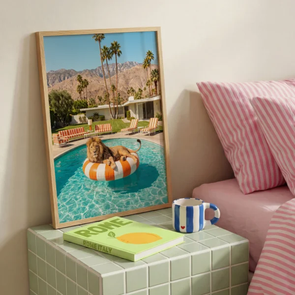 Lion on orange pool ring framed print beside pink striped bedding