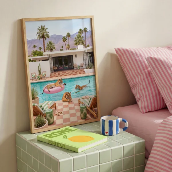Three tigers pool party framed print beside pink striped bedding