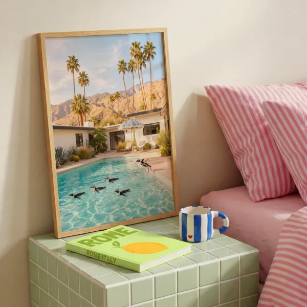 Penguins swimming in pool framed print beside pink striped bedding