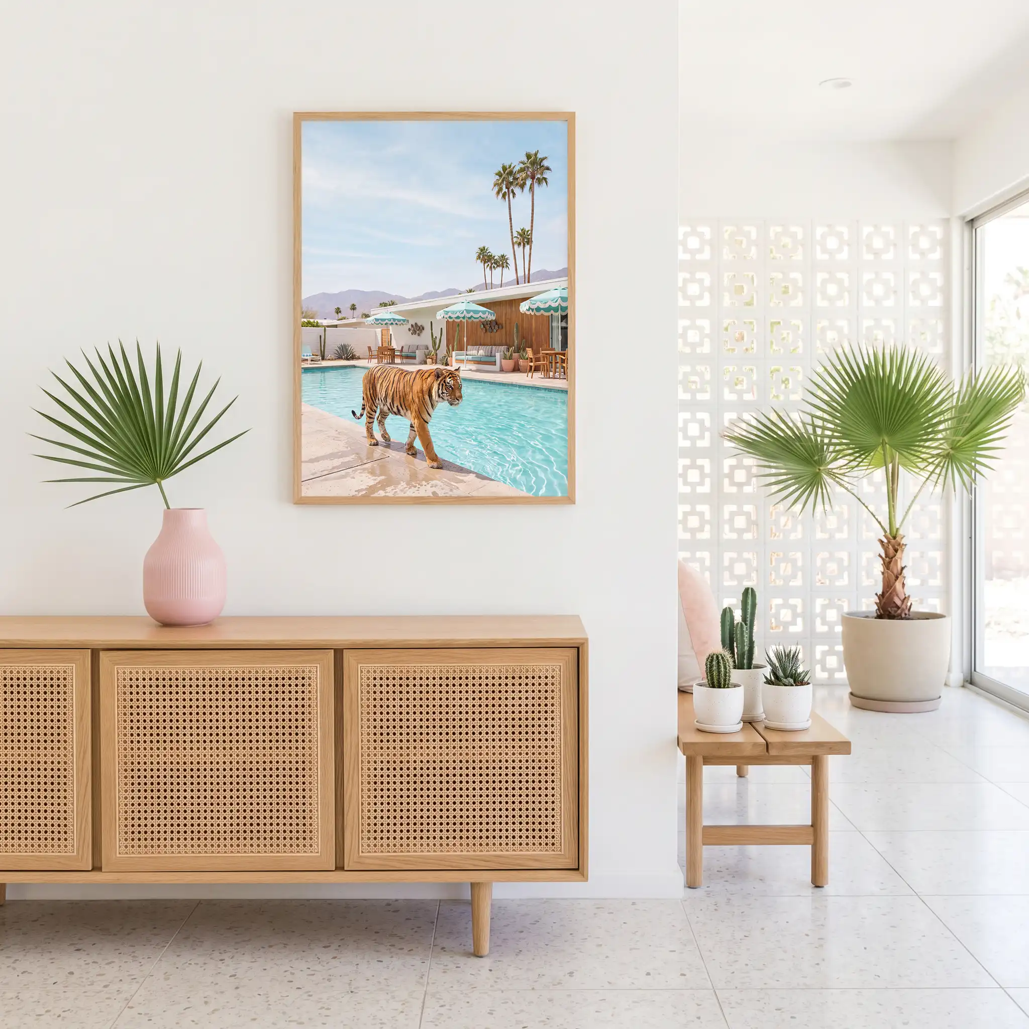 Tiger resort pool wall art above a cane-front console in a bright interior